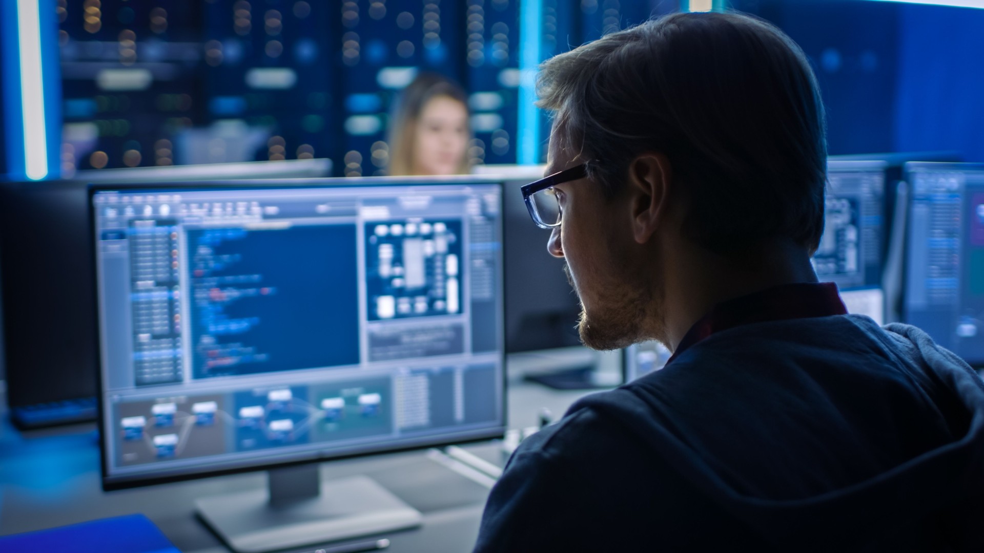Smart Male IT Programer Working on Desktop Computer in Data Center Technical System Control Room. Équipe de jeunes professionnels programmant en langage de codage